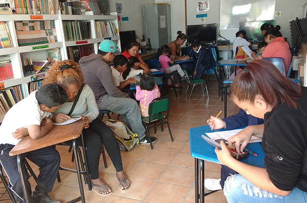 Niños y familiares estudian en la Biblioteca de la escuela Sor Juana